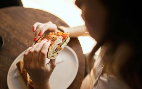 Closeup of a woman eating a sandwich 