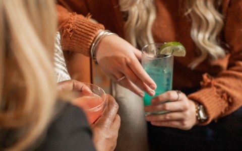 person holding a blue cocktail