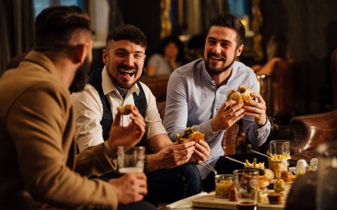 group of guys laughing while eating