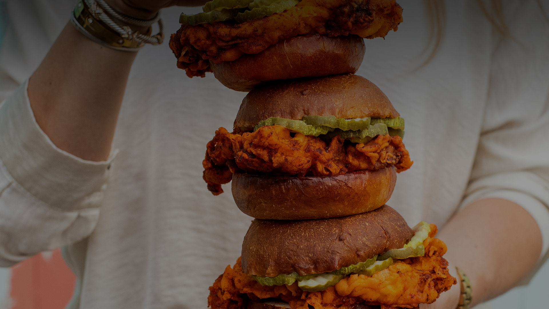 chicken sandwiches with pickles stacked up 