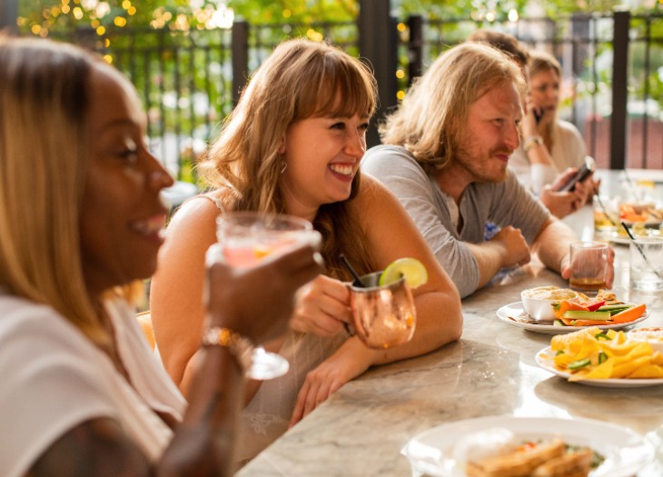 Group of people enjoying cocktails and food