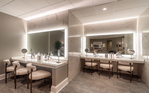 vanities with backlit mirrors and chairs