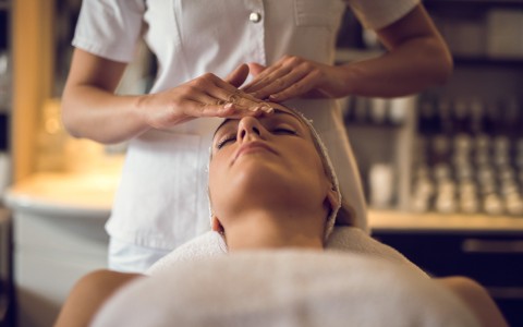 guest receiving a massage on her forehead