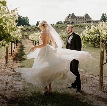 bride twirling around groom out in the vineyard