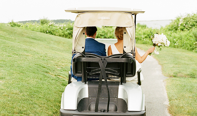 bride and groom driving away in a golf cart
