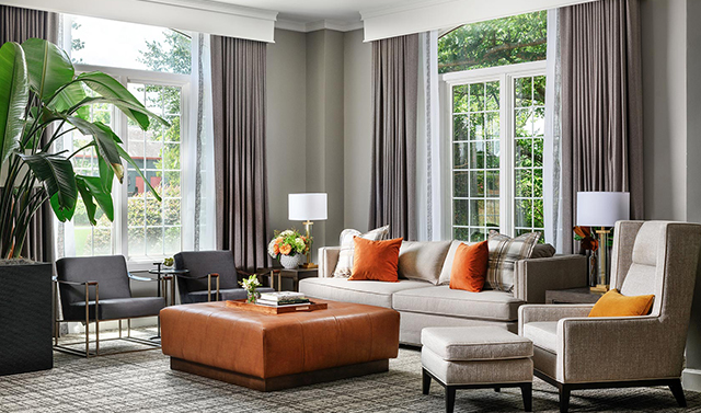 living room area with orange foot rest and orange accent pillows