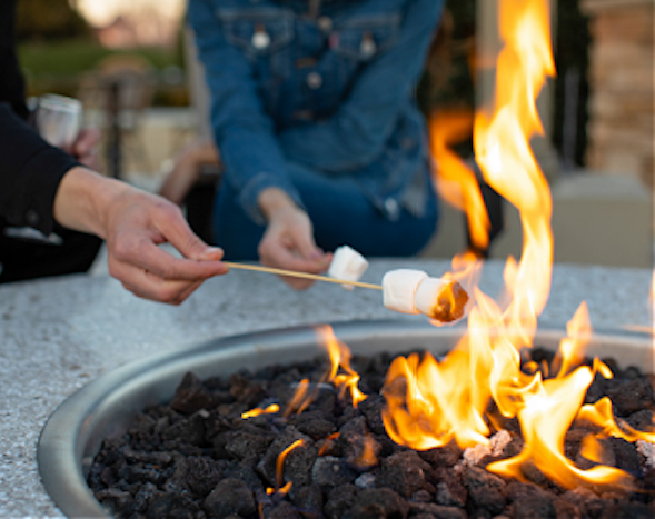 man and woman roasting marshmallows fireside