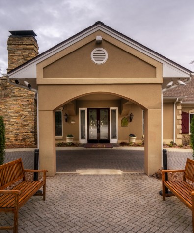 two benches seated from across the driveway by the exterior of spa entrance
