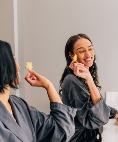 two women in grey robes holding a star shaped item and smiling