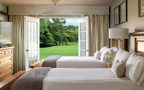two beds with french doors opening up to green lawn