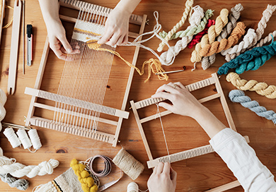 people using a stringing machine for a crafting project