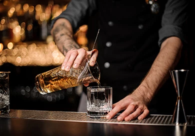 bartender pouring bourbon into a glass