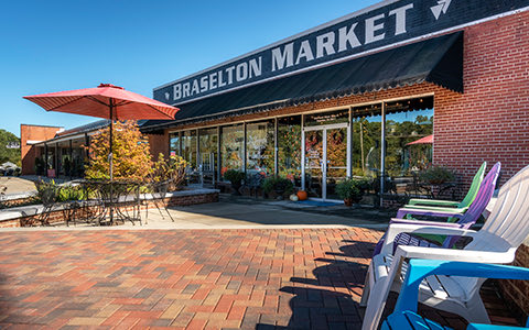 exterior of braselton market with chairs outside of it