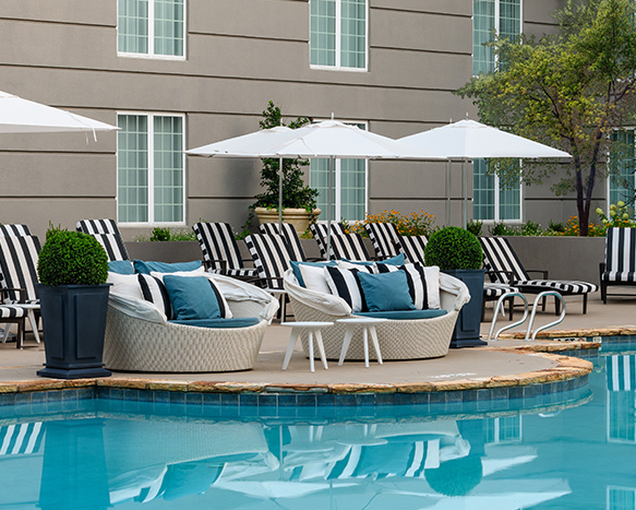 outdoor pool with lounge seating and umbrellas around it