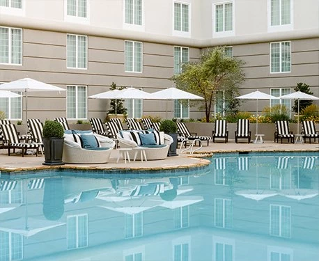 outdoor pool surrounded by lounge chairs and umbrellas 