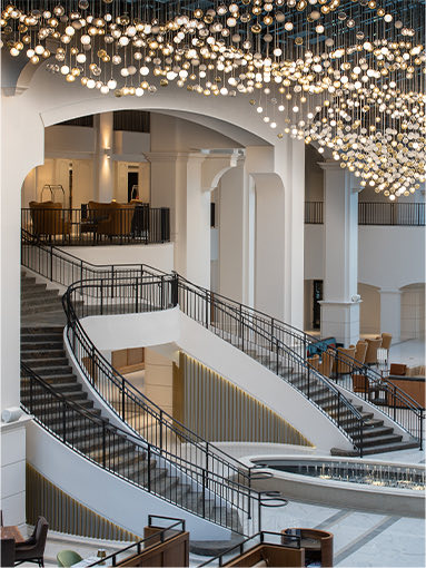 atrium with hanging lights and a double staircase