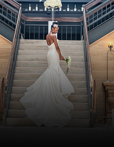 bride in a trumpet style dress on the stairs looking over her shoulder