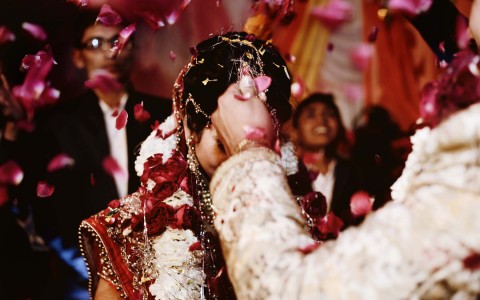 indian wedding celebration with bride being showered in items