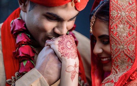indian couple with man kissing womans hand