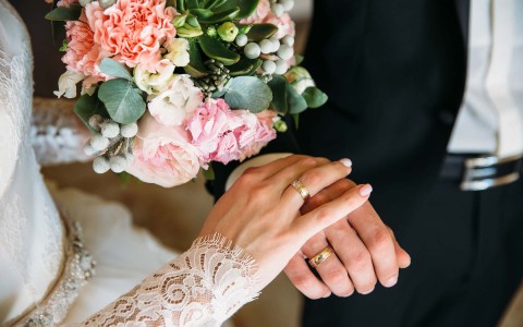 close up shot of couples hands with wedding rings on