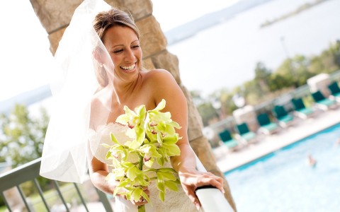 a bride holding a bouquet of flowers and smiling