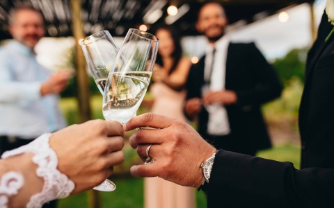 a bride and groom toasting glasses of champagne