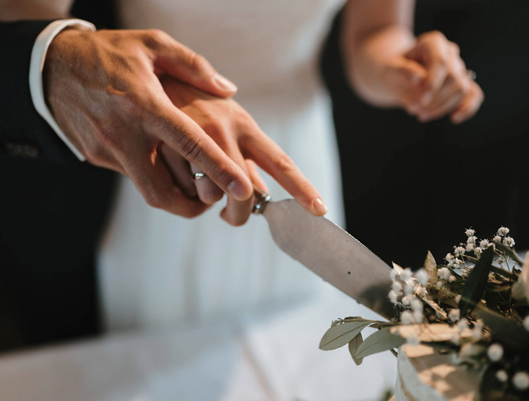 closeup of a bride and groom cutting their wedding cake
