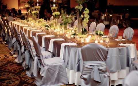 Long table set with fabric wrapped chairs & plant centerpieces