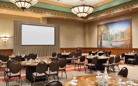 Room with round tables & seating facing projection 