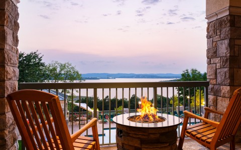 fire pit on a balcony facing a lake at sunset