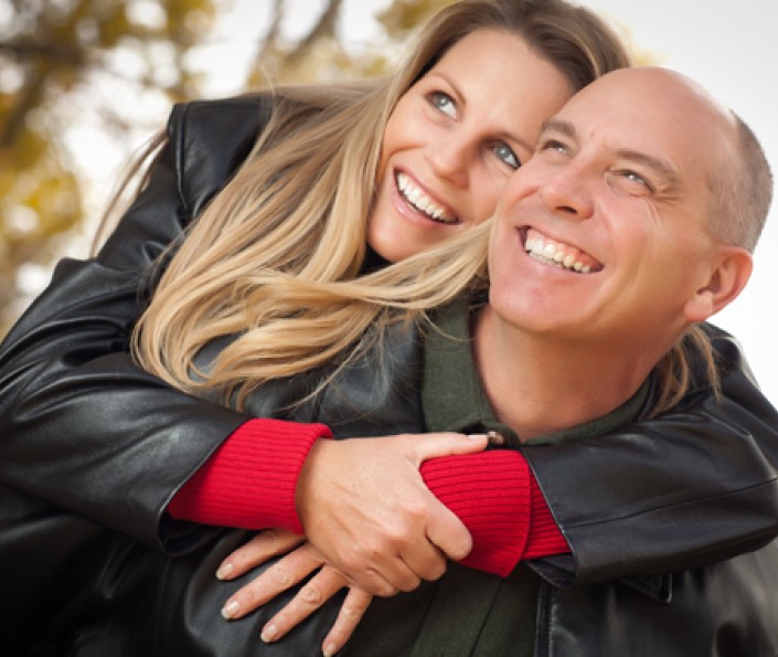 husband and wife outside hugging and smiling