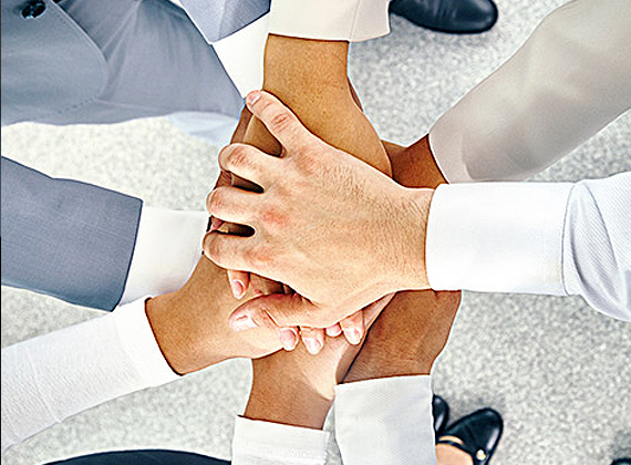 employees putting their hands together