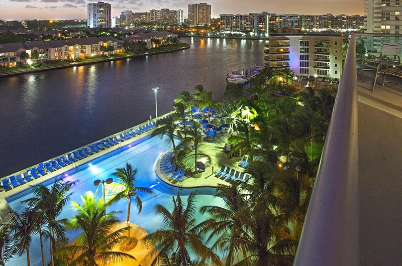 the pool area at a hotel on the water