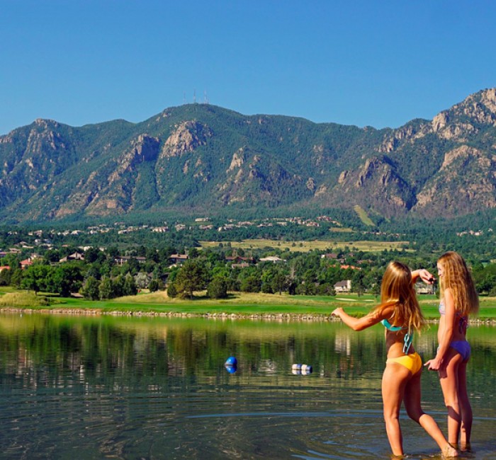 two girls skipping rocks on the lake