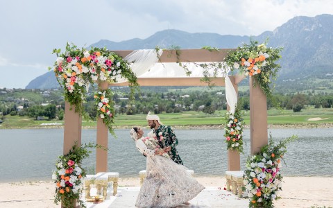 A married couple hugging on their wedding ceremony next to a lake