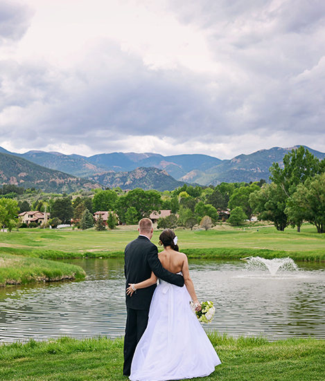 Back view of a married couple looking at a lagoon with a little fountain 