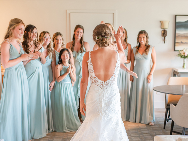 A bride and her bridesmaid high five each other 