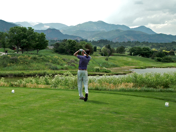 A man playing golf on a large field