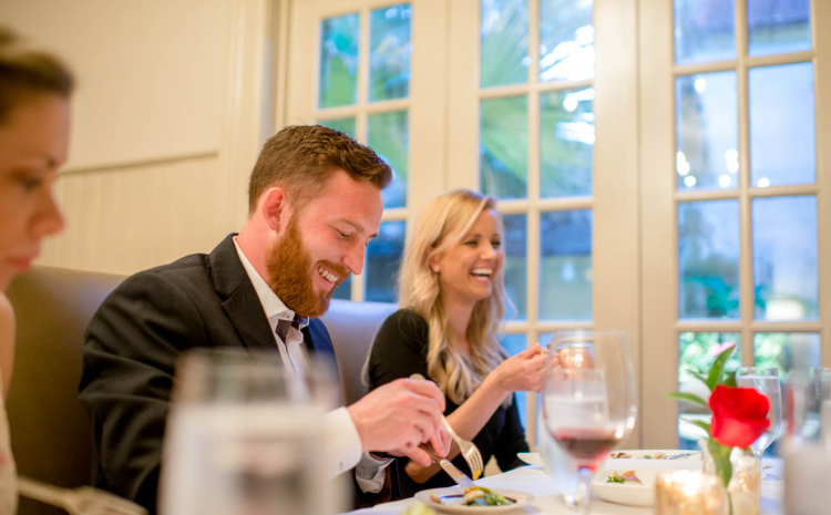 Couple laughing as they eat at table