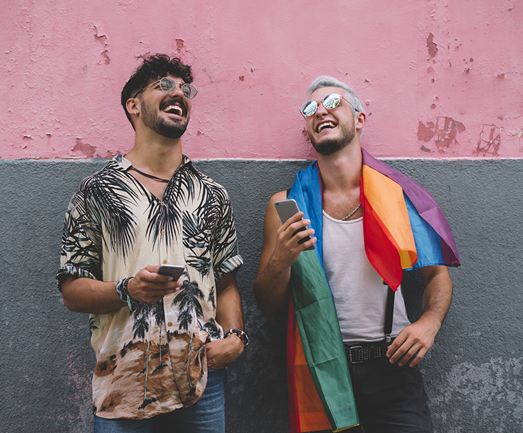 to men laughing at pride fest with pink and grey wall behind them