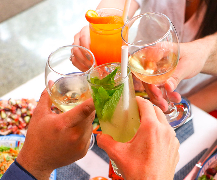 hand of a woman holding up a wunderbar branded cup of a citrus cocktail