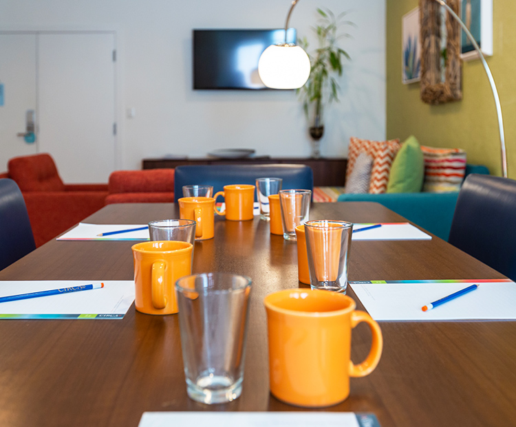 meeting table with paper and coffee mugs laid out