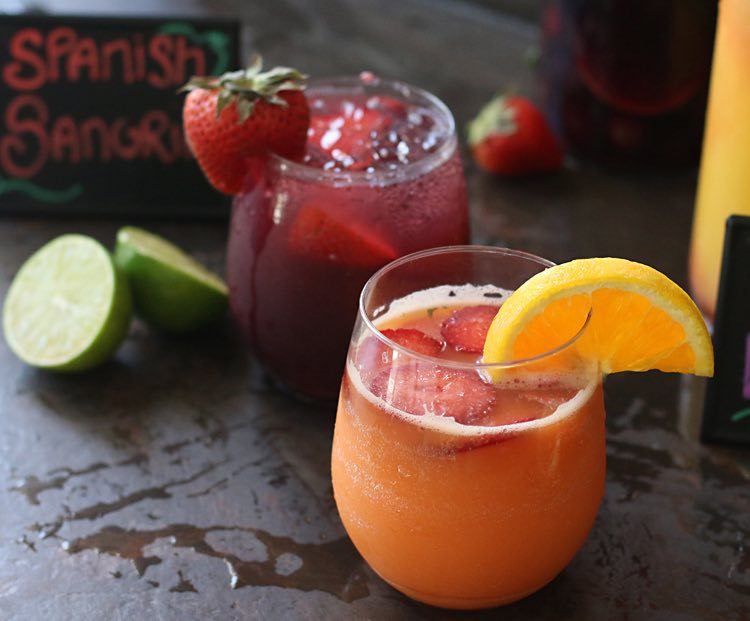 rum cocktails garnished with an orange slice and strawberry