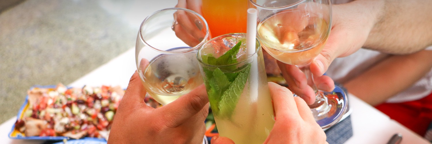 four friends clinking glasses of cocktails 