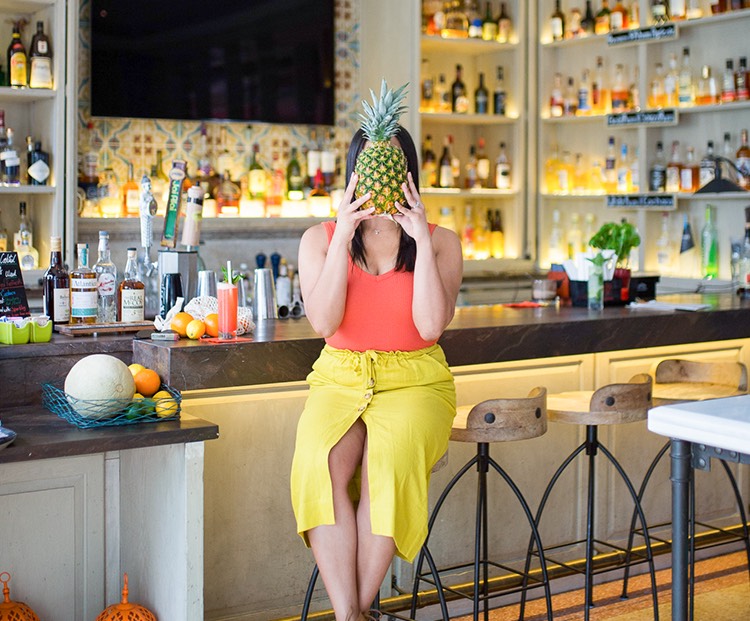 woman sitting at a wunderbar stool holding a pineapple