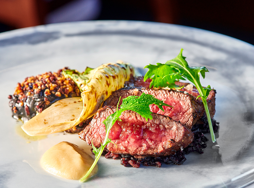 steak on a plate with other food and herbs