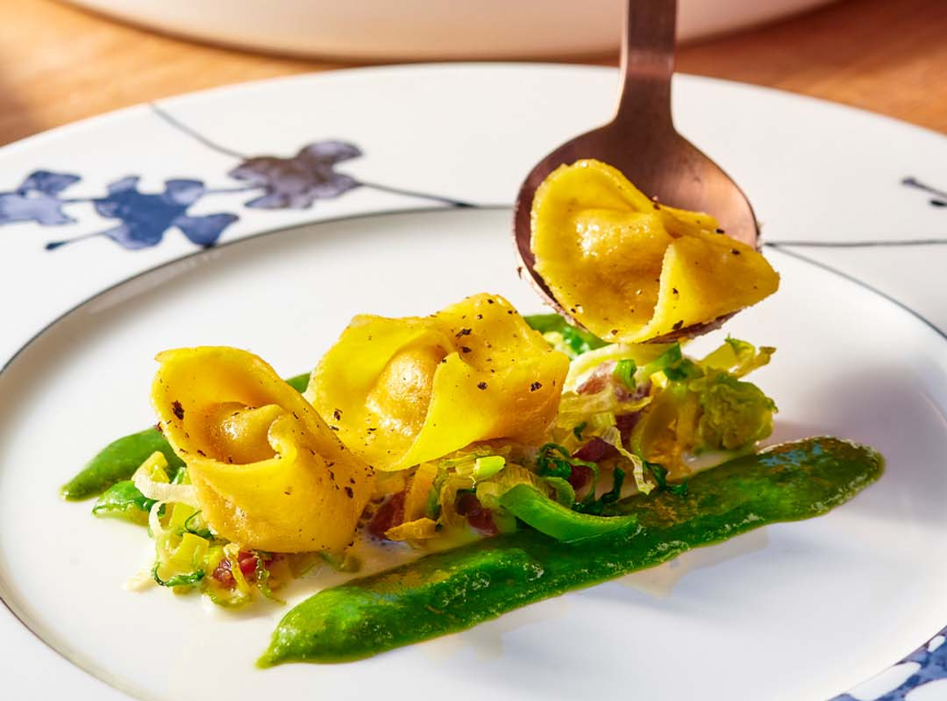 Pasta being plated on a white plate