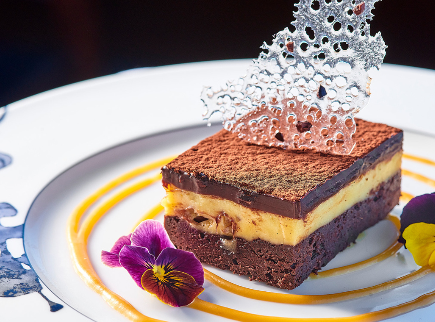 Beautifully plated chocolate dessert with decorative flowers