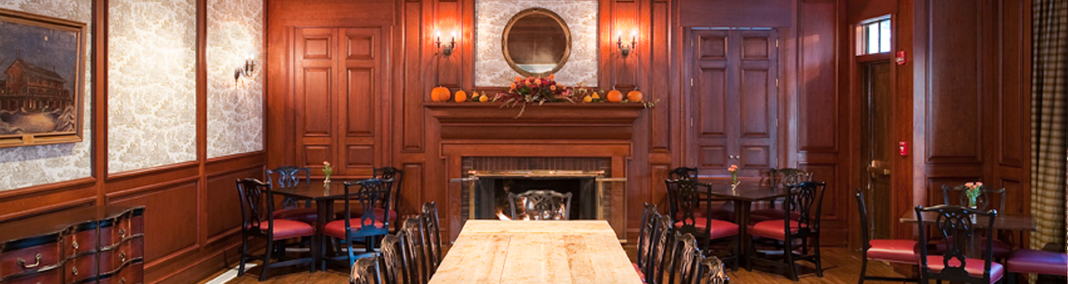 a large dining table in front of a fireplace