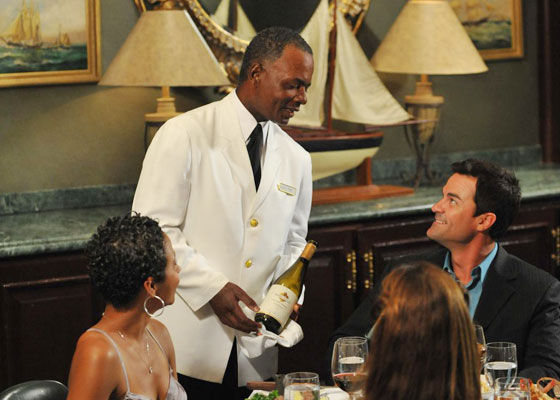 Waiter presenting wine to table of 3 guests dining